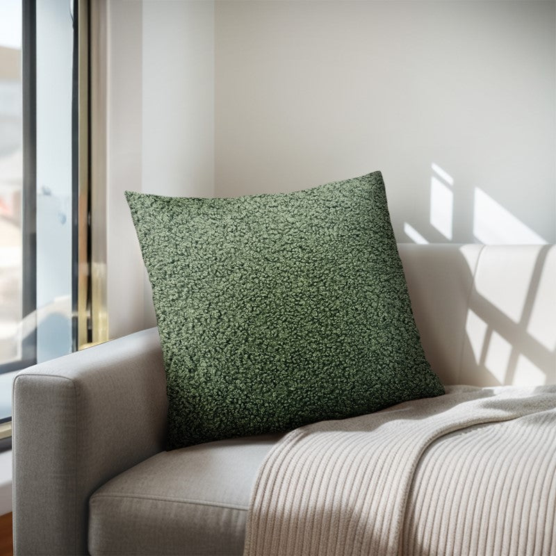 Green textured pillow on a beige sofa with natural light