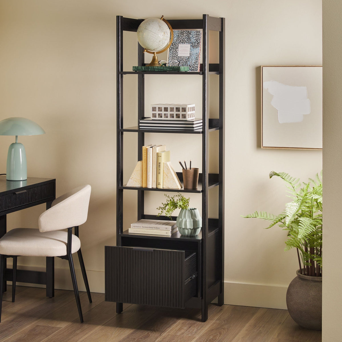 Tall black bookshelf with decorative items in a home office setting.