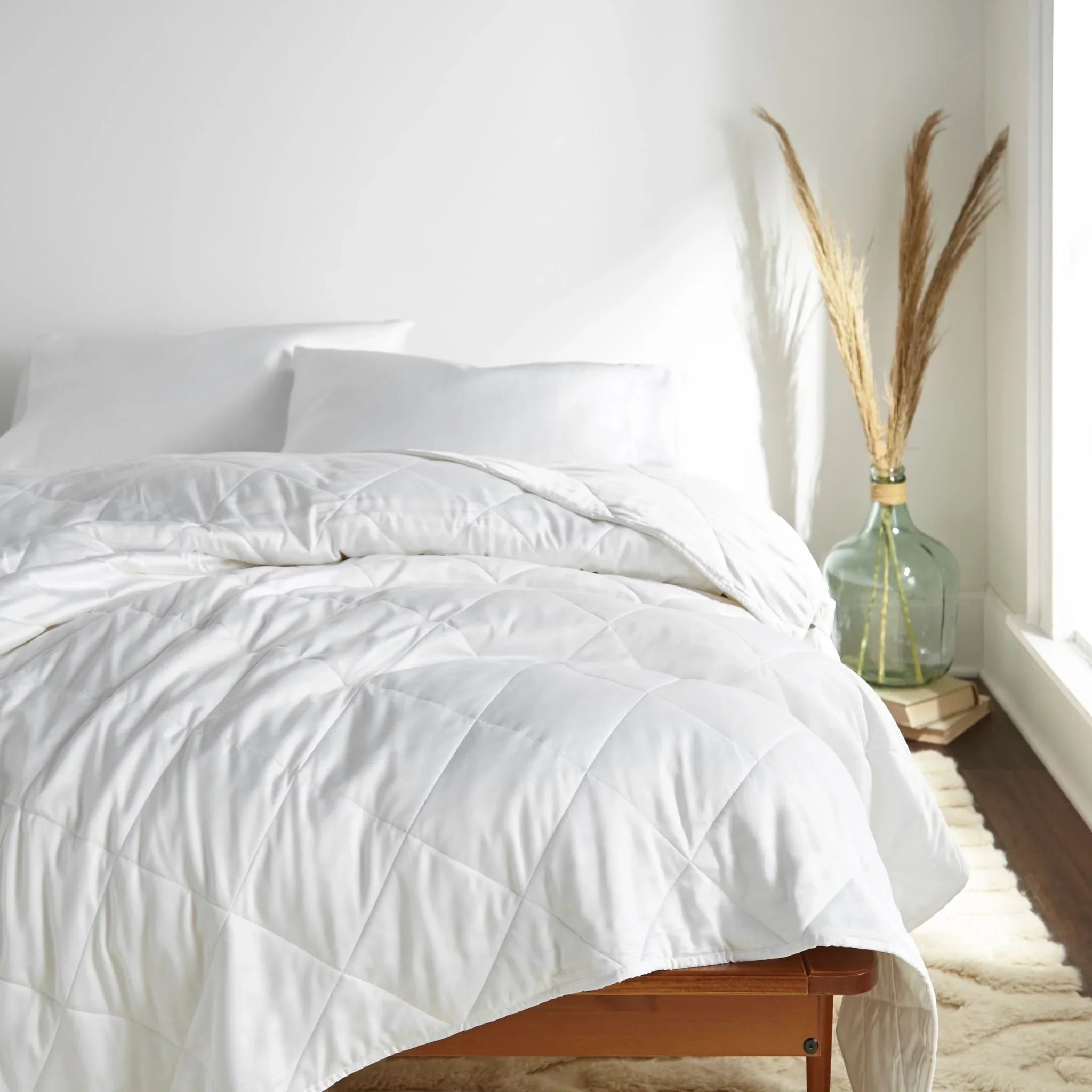 Eye-level shot from the right side of the bed featuring  bamboo comforter smoothly laid out, highlighting its soft drape and elegant texture. Main image