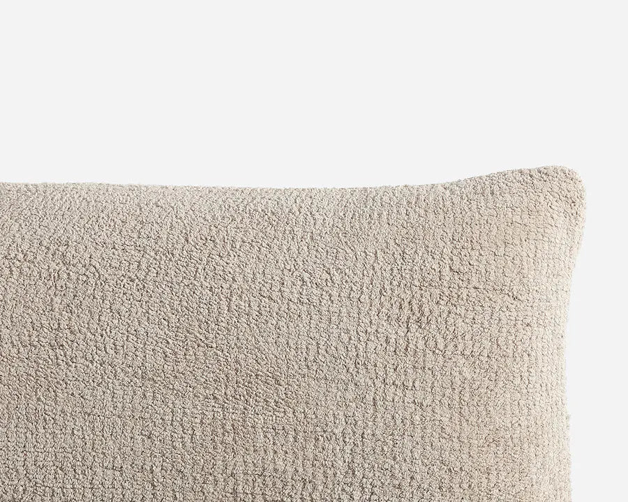 Textured beige pillow on a light gray background