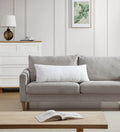 Gray sofa in a living room with a wooden coffee table and lamp.