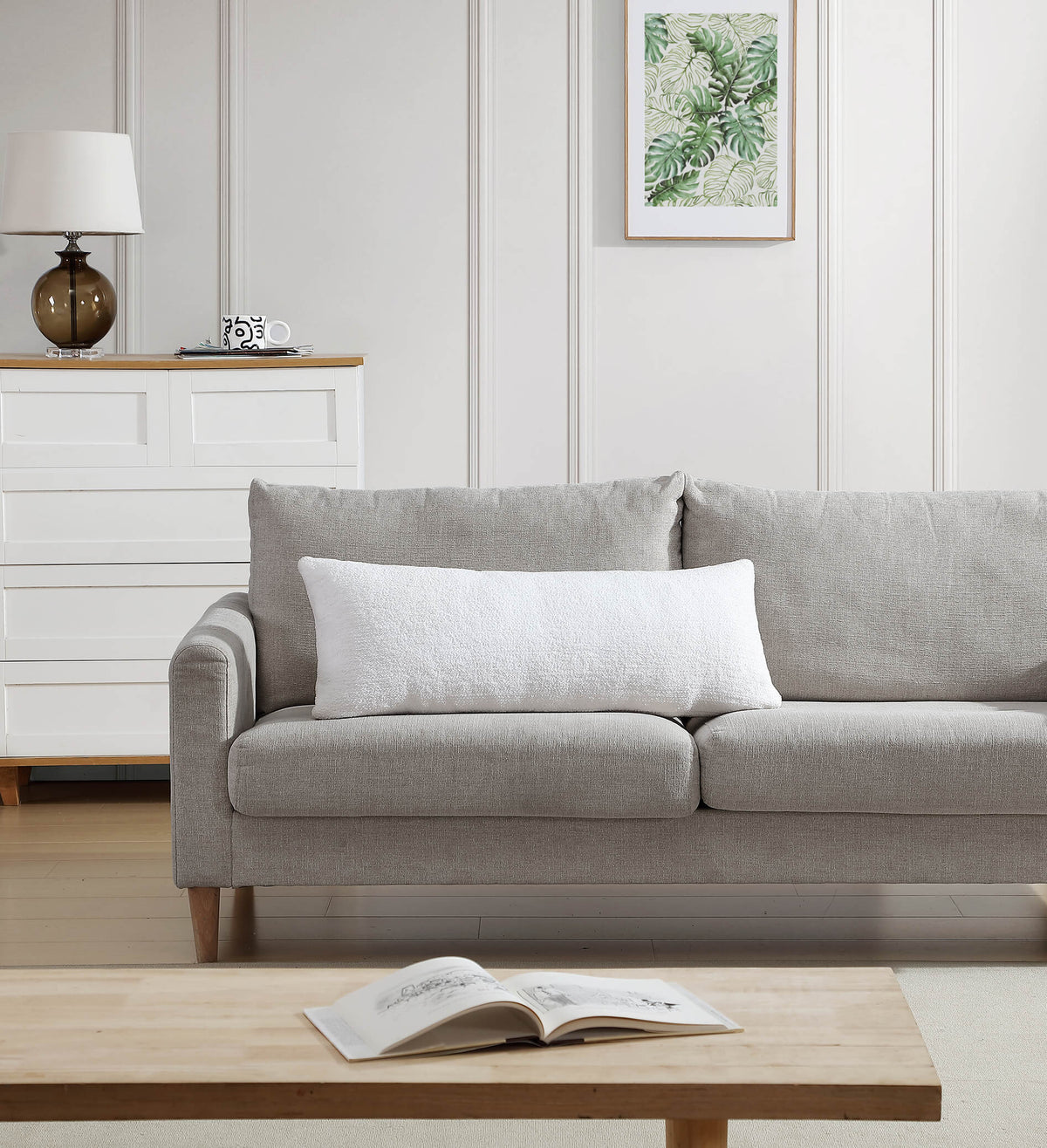 Gray sofa in a living room with a wooden coffee table and lamp.