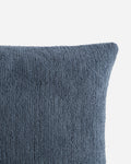Close-up of a textured blue pillow on a light gray background
