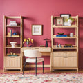 Wooden office furniture set with shelves, desk, and chair against a pink wall.
