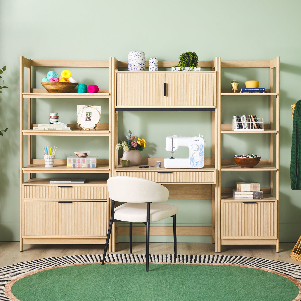 Wooden office setup with shelves, desk, and chair against a green wall.